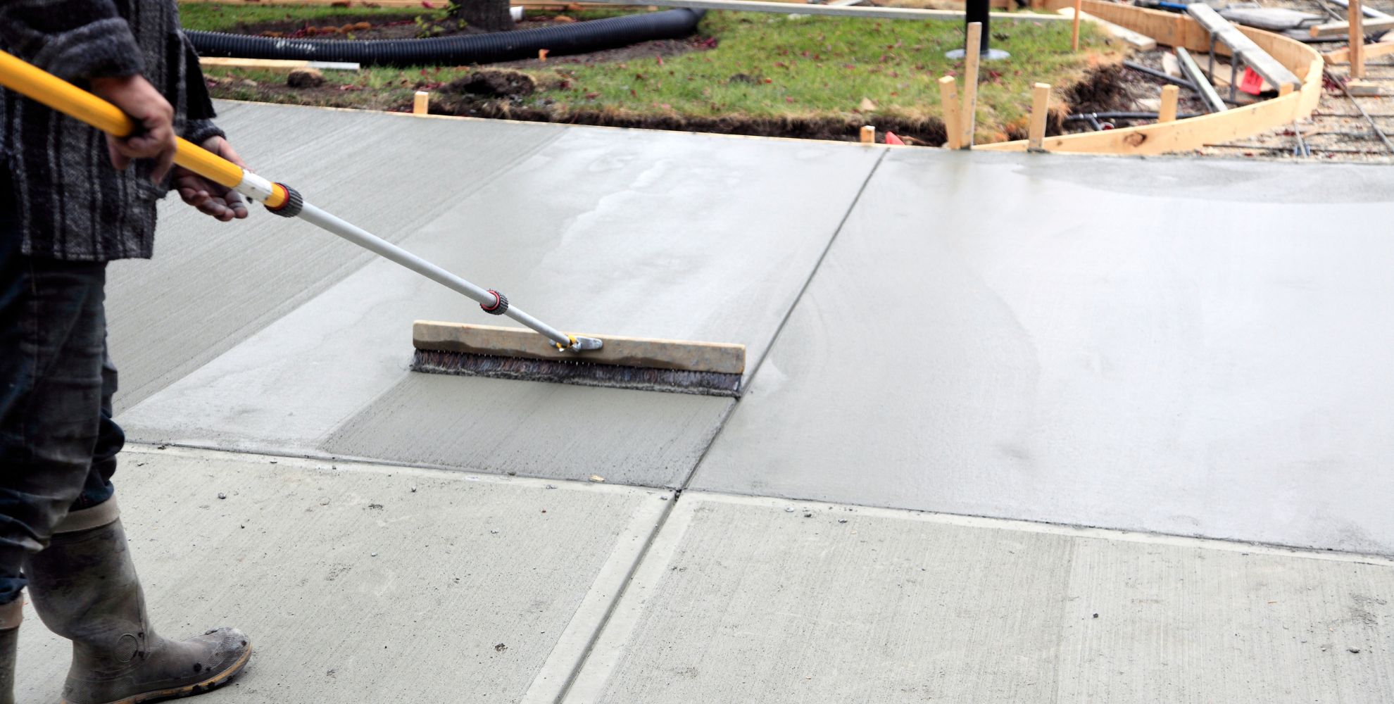 smoothing out a freshly poured slab of concrete at a residential jobsite in San Antonio, TX